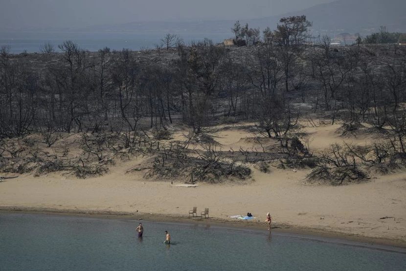Η απόκοσμη εικόνα από παραλία της Ρόδου που κάνει τον γύρο του κόσμου:  Λουόμενοι με φόντο τα καμμένα